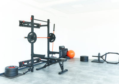 Trainingsraum mit Sport-/Trainingsgeräten in schwarz orange gehalten - Sport & Schmerz Campus